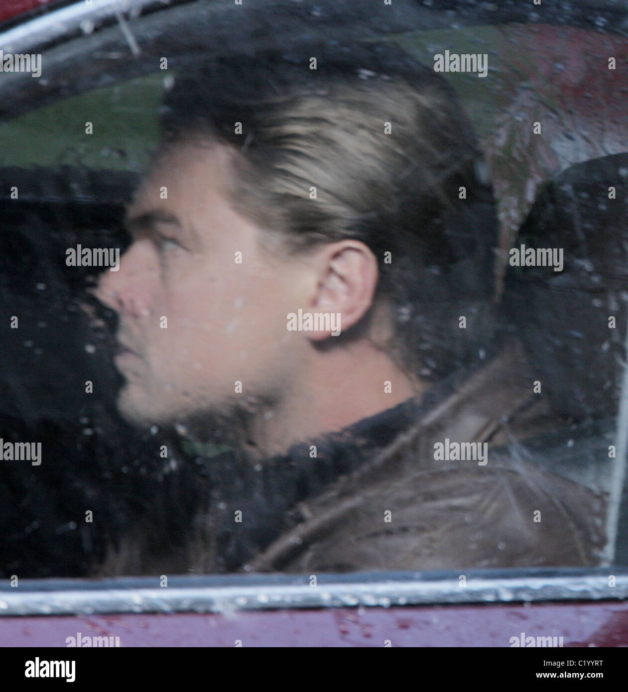 Leonardo DiCaprio driving a car in the rain while filming a scene for