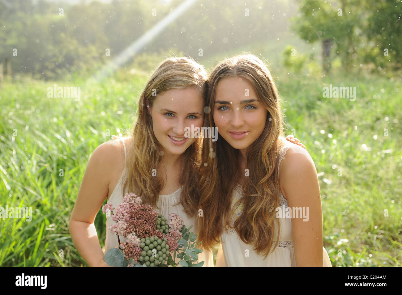 Sister's with Flowers in a green Australian field Stock Photo