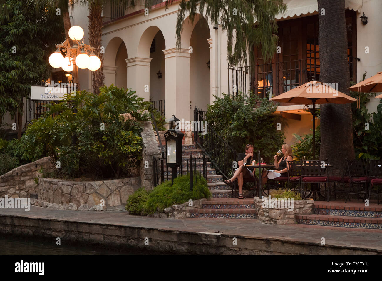 Two people eating and drinking wine on the San Antonio River Walk Texas USA Stock Photo