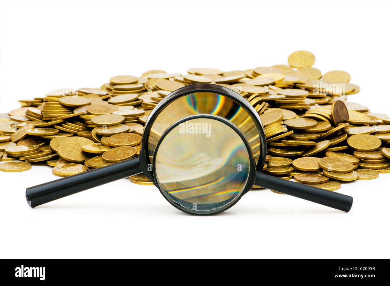 Magnifying glass and coins isolated on white Stock Photo - Alamy