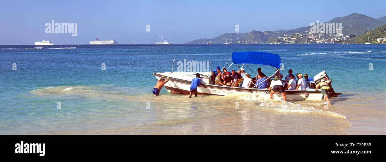 Water taxi departing Grand Anse Bay beach returning group of people