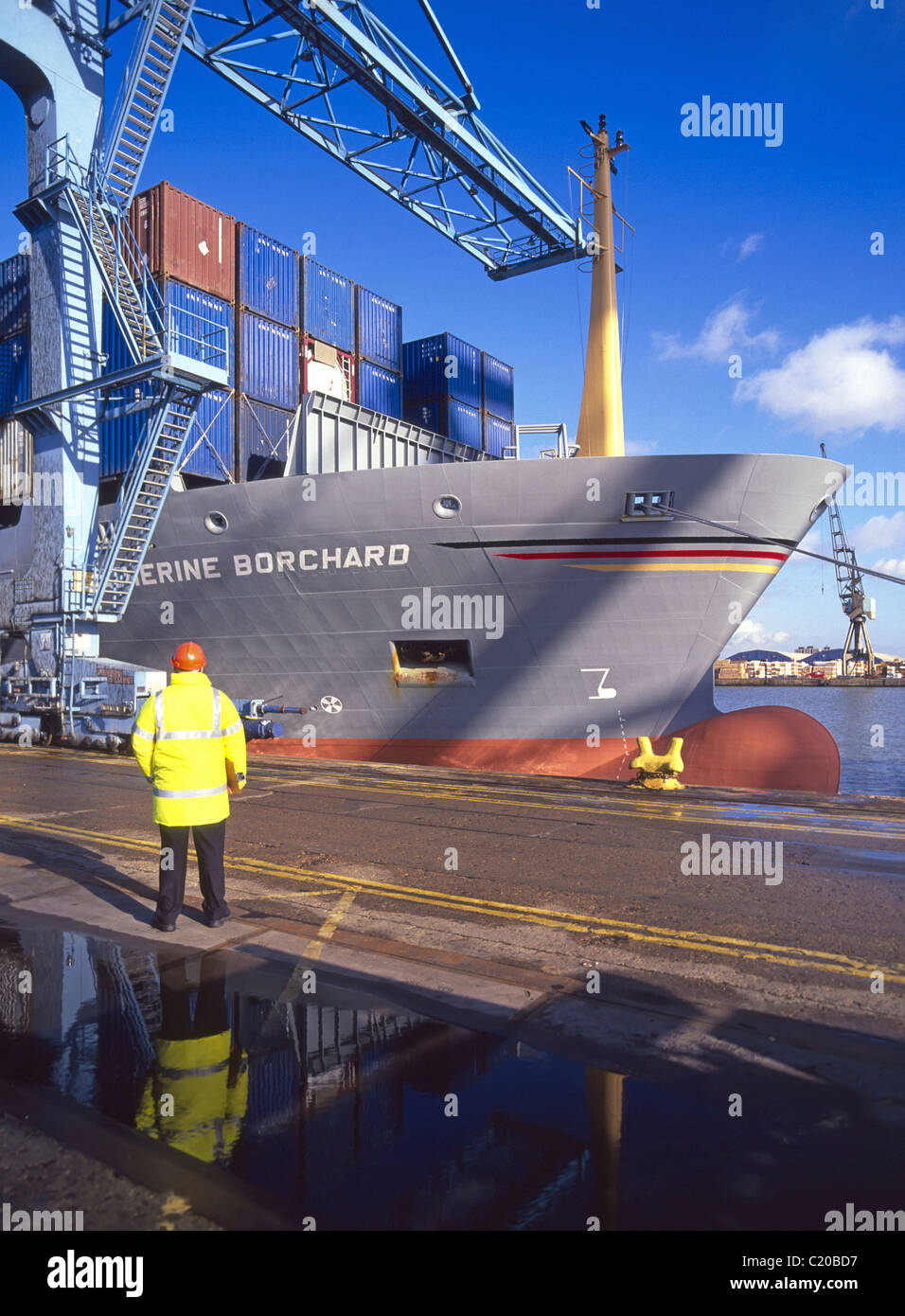 Dockside supervisor standing beside container ship Stock Photo