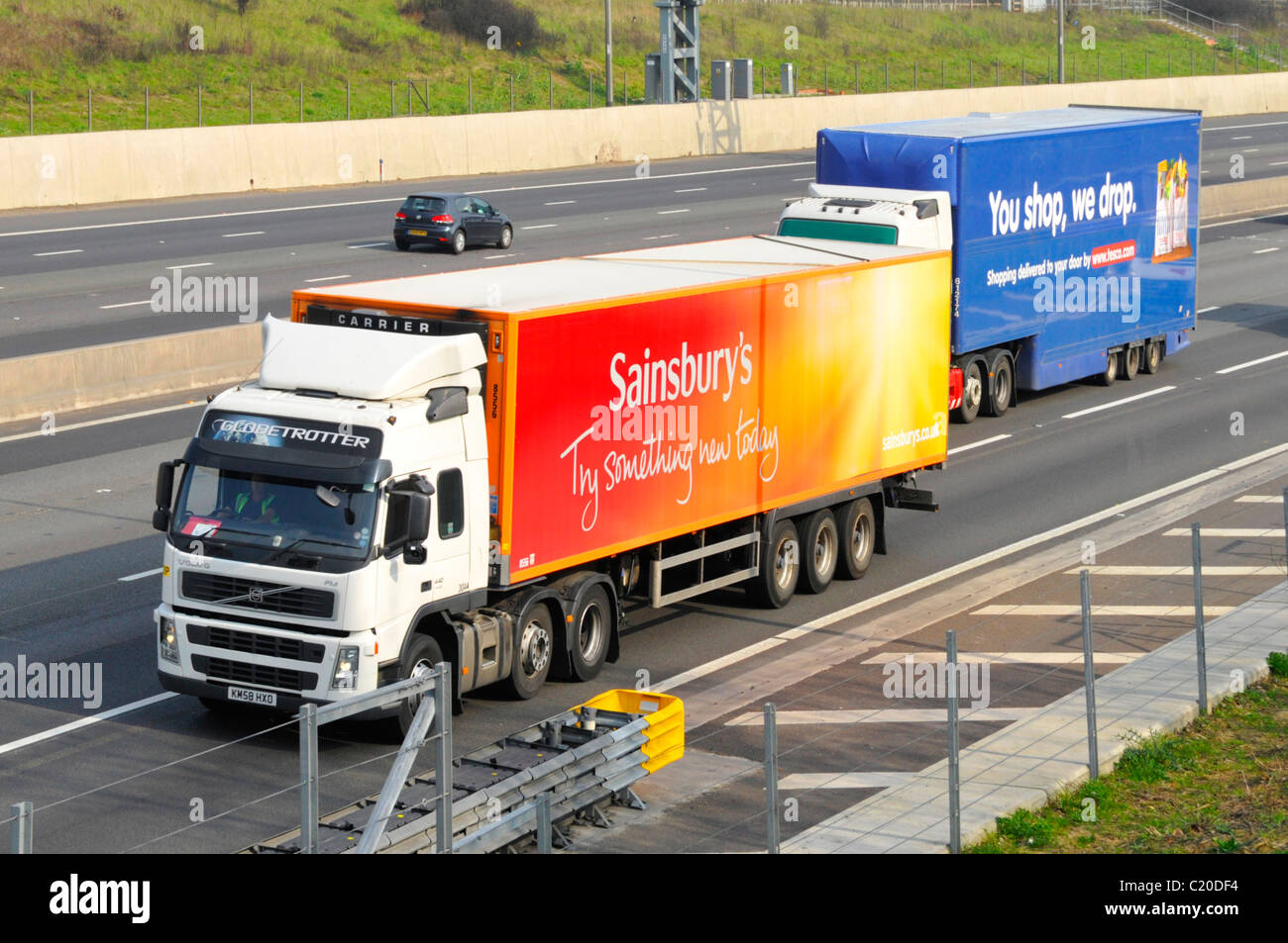 Tesco lorry about to overtake a Sainsbury truck Stock Photo
