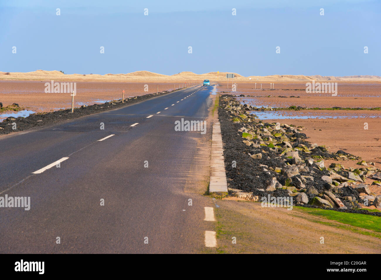 Vehicle crossing causeway to Holy Isle, Northumberland, England Stock Photo