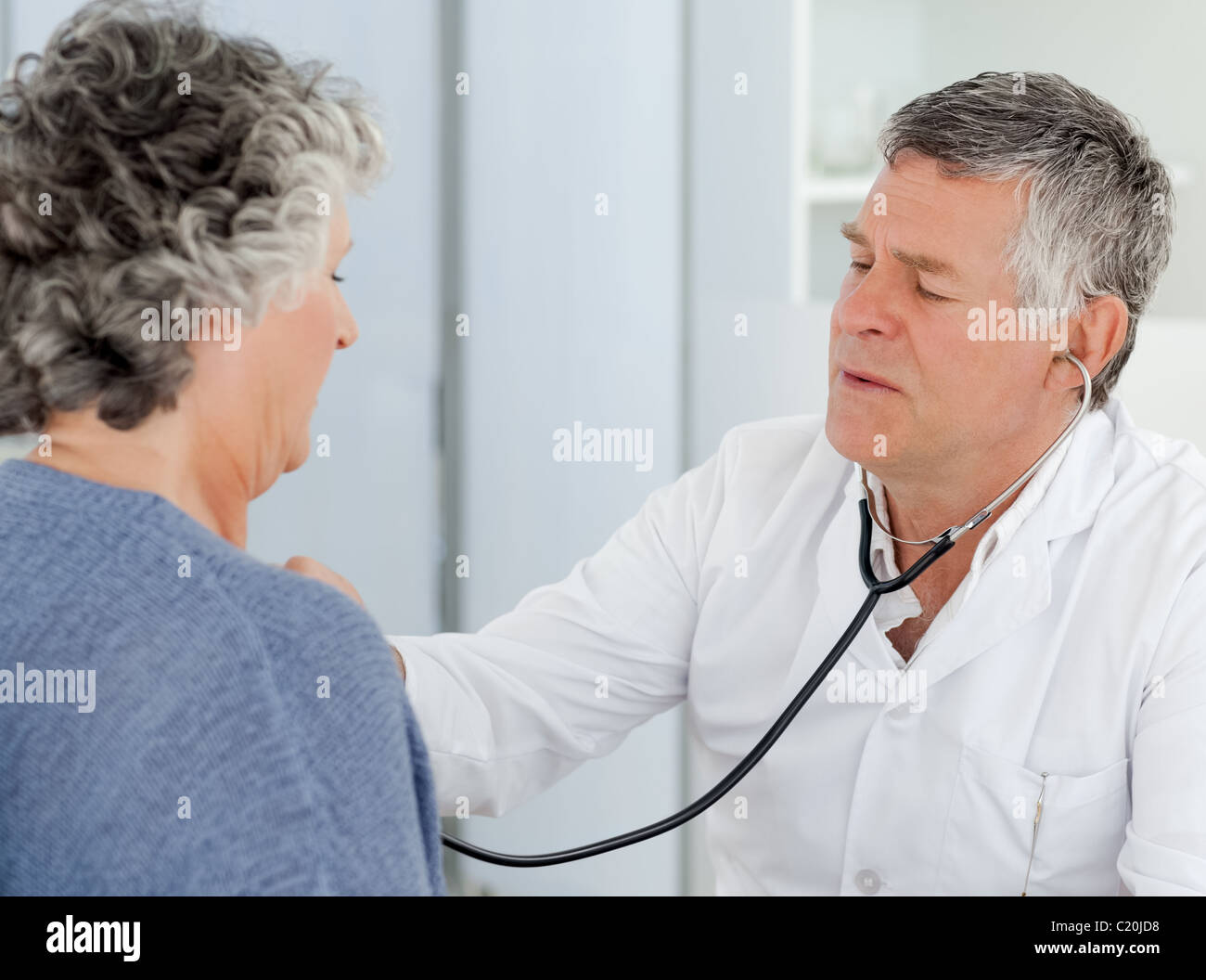 A senior doctor doing a check-up to his patient Stock Photo