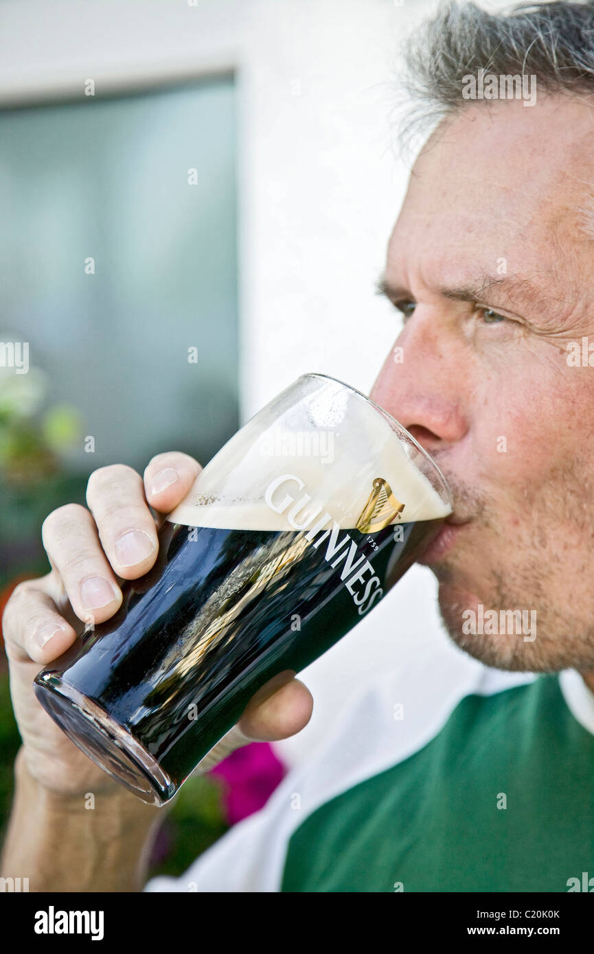man drinking a guinness Stock Photo