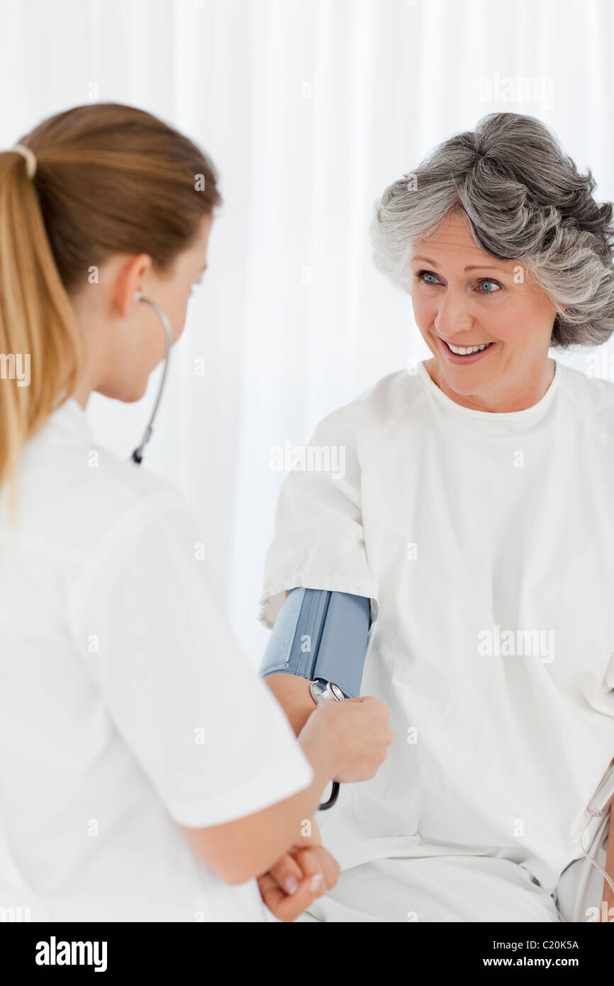 Nurse taking the blood pressure of her patient Stock Photo Alamy