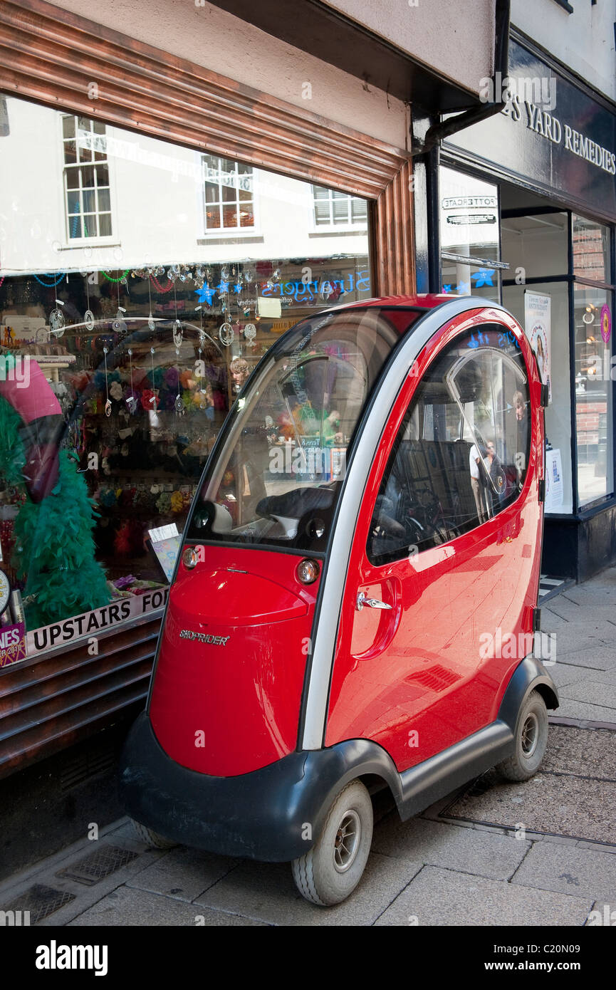 Shoprider mobility scooter parked on a pavement outside a shop in a