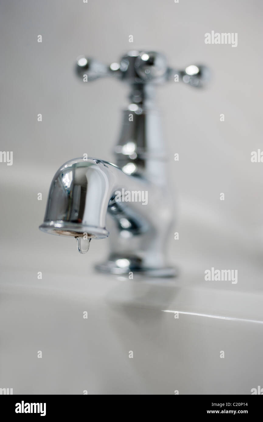 Metal tap in white bathroom with dripping water Stock Photo Alamy