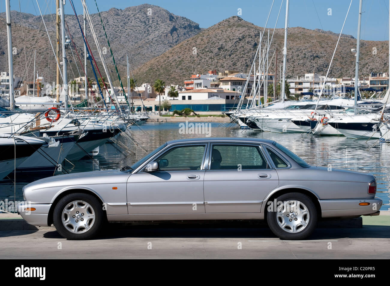 Side view of a Jaguar V8 XJ series car parked at a marina in Spain. Stock Photo