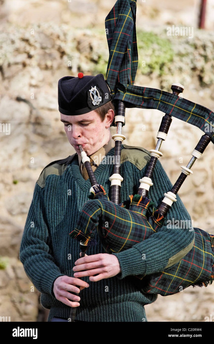 A member of the British Army’s Officer Training Corps (OTC) playing the bagpipes in a solo piping competition. Stock Photo