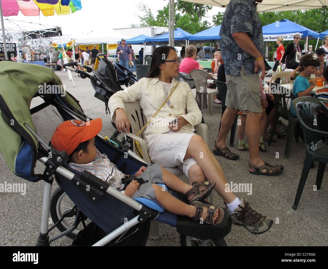 A modern Asian woman and her son resting at a farmers market in Austin, Texas. Stock Photo