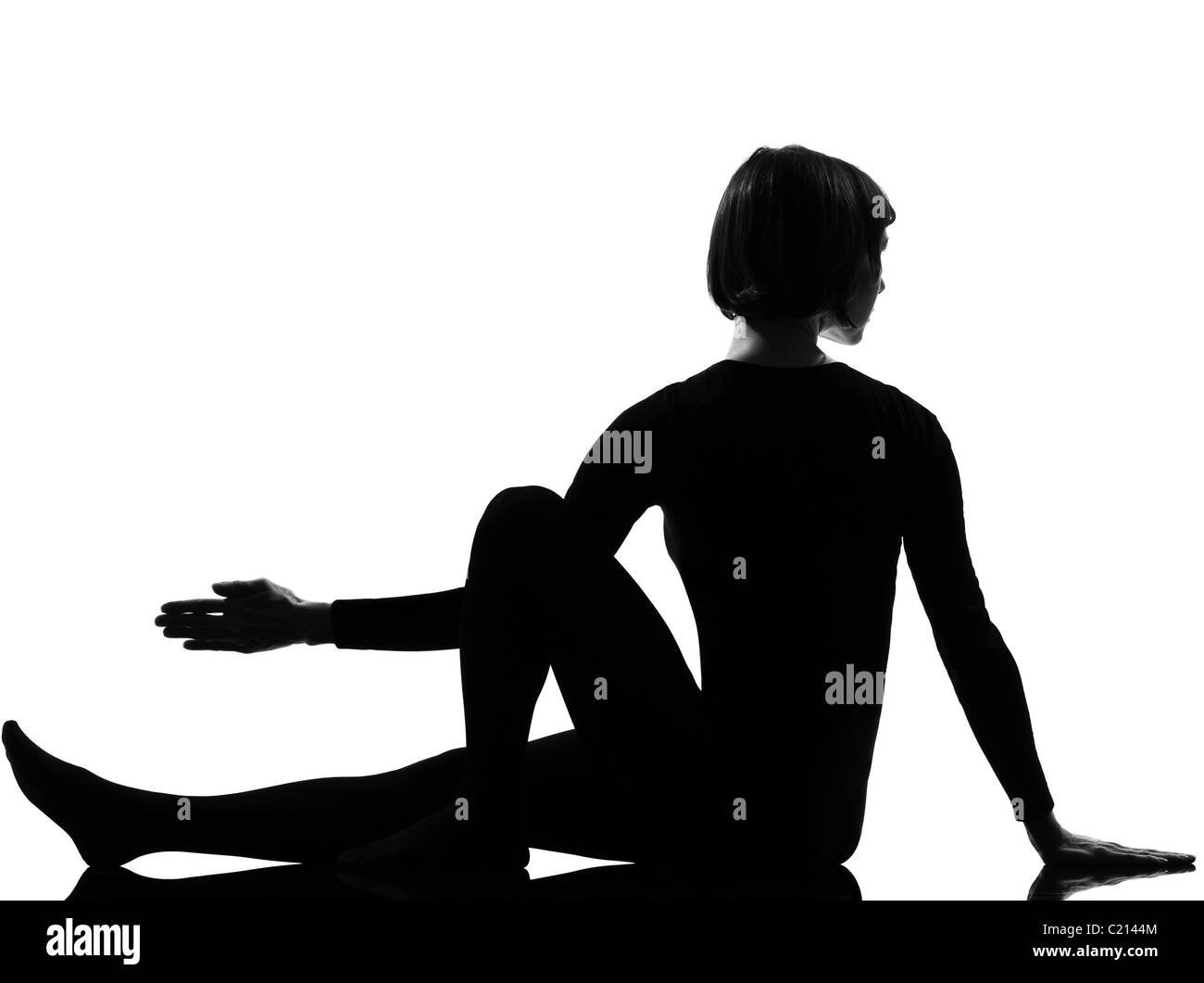 woman Marichyasana yoga sage pose posture position in silouhette on studio white background full length Stock Photo
