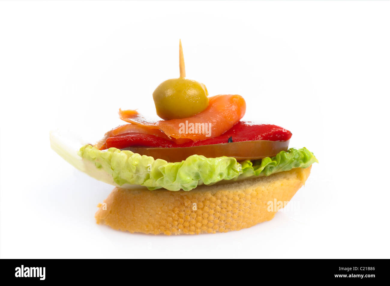 Small canape of smoked salmon, lettuce, peppers and tomato on a slice of baguette. Stock Photo