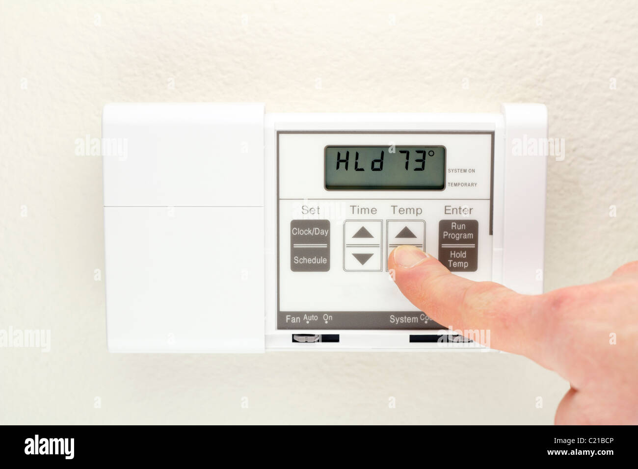 HVAC home thermostat of an energy efficient heating and cooling air conditioning system. Change control of heating cooling digital wall panel display. Stock Photo
