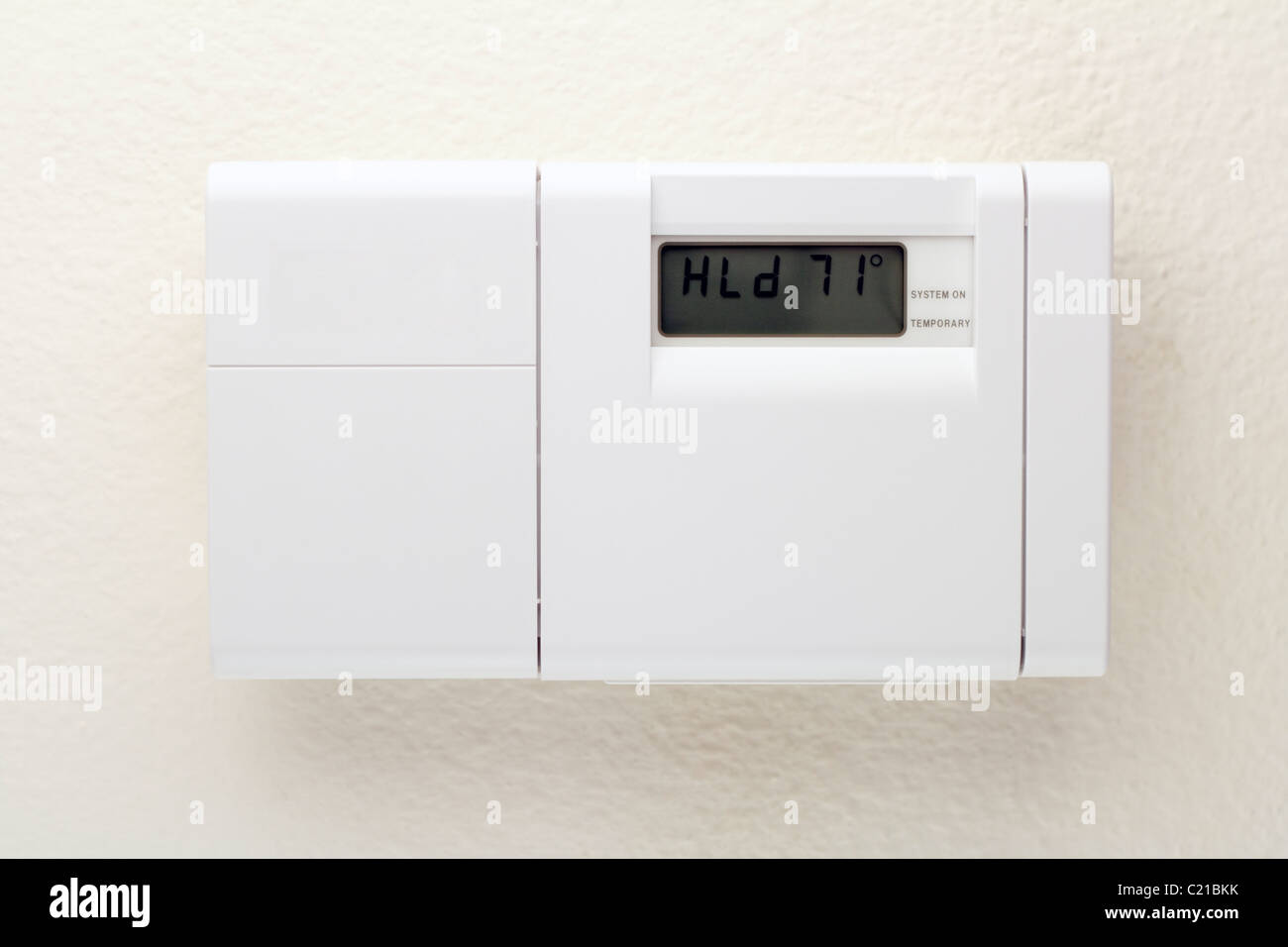 Electronic control panel that controls cooling and heating. Outside of a white heating, ventilating, and air conditioning control panel on a wall. Stock Photo