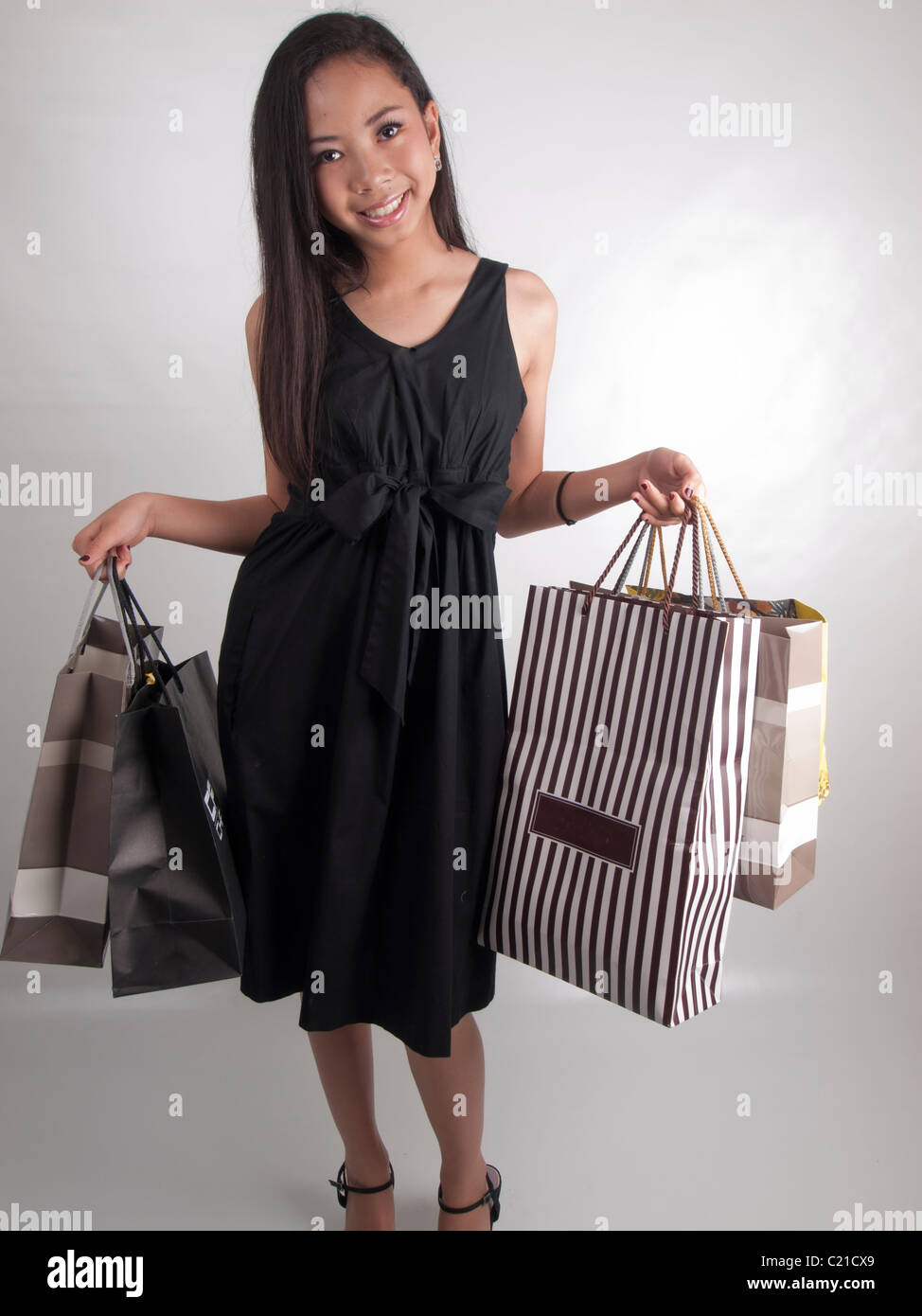 A young Asian woman having a good shopping time showing her shopping bags Stock Photo