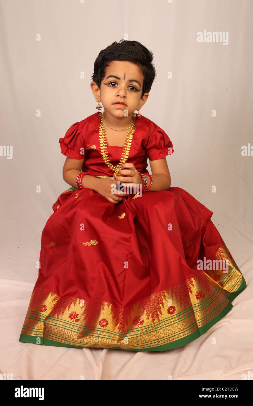 a girl child clad in red dress Stock Photo