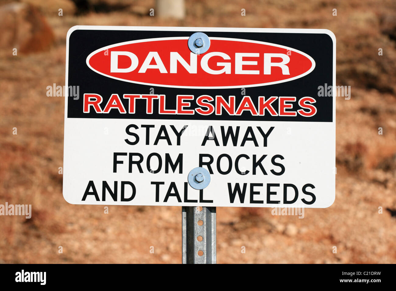 red white and black danger rattlesnakes sign on a post Stock Photo