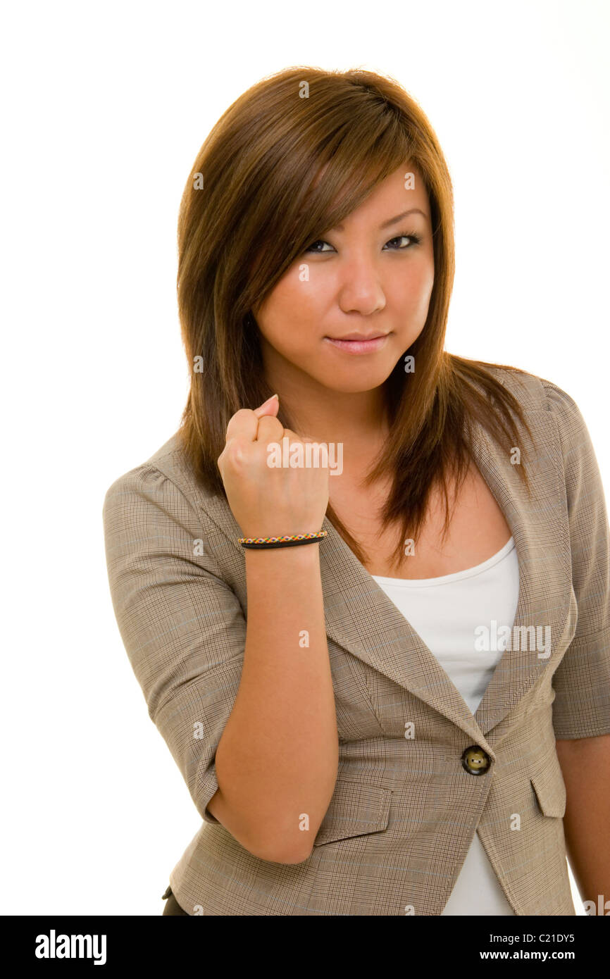 Angry young Asian woman in business suit holding her right hand in a fist. Stock Photo