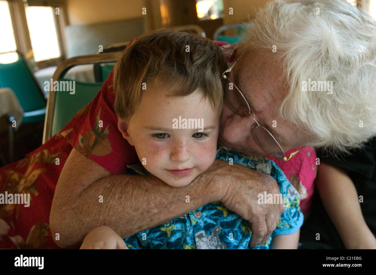 2 year old boy enjoying an embrace from his grandmother. Stock Photo