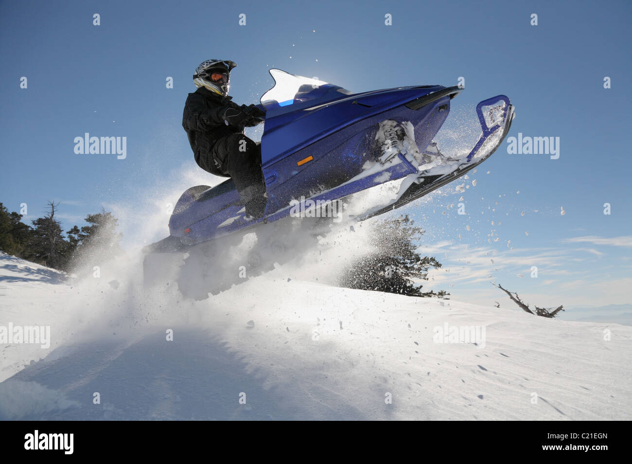 man and fast action snowmobile jumping Stock Photo