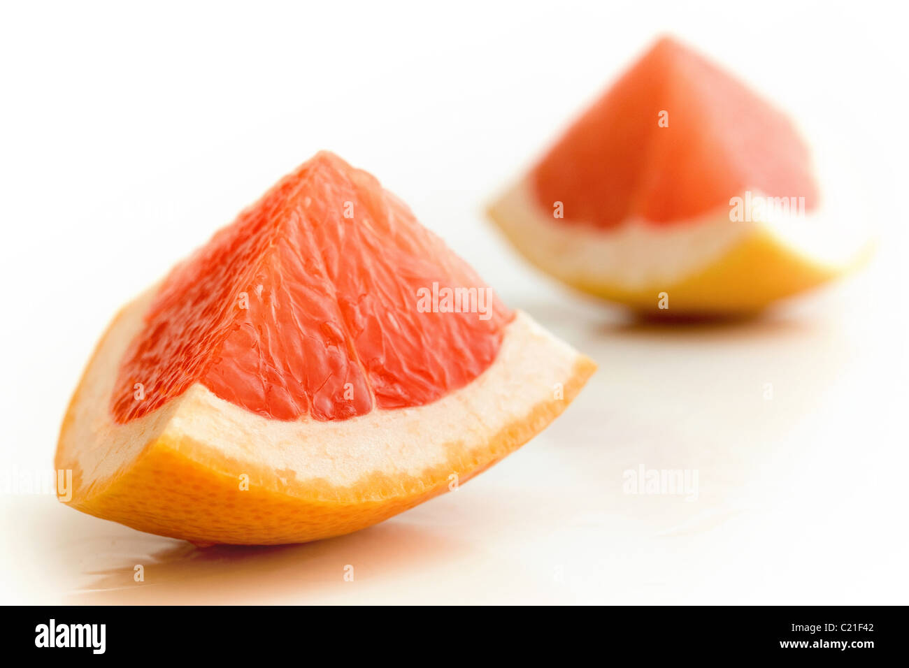 Fresh delicious pieces of grapefruit over white background Stock Photo