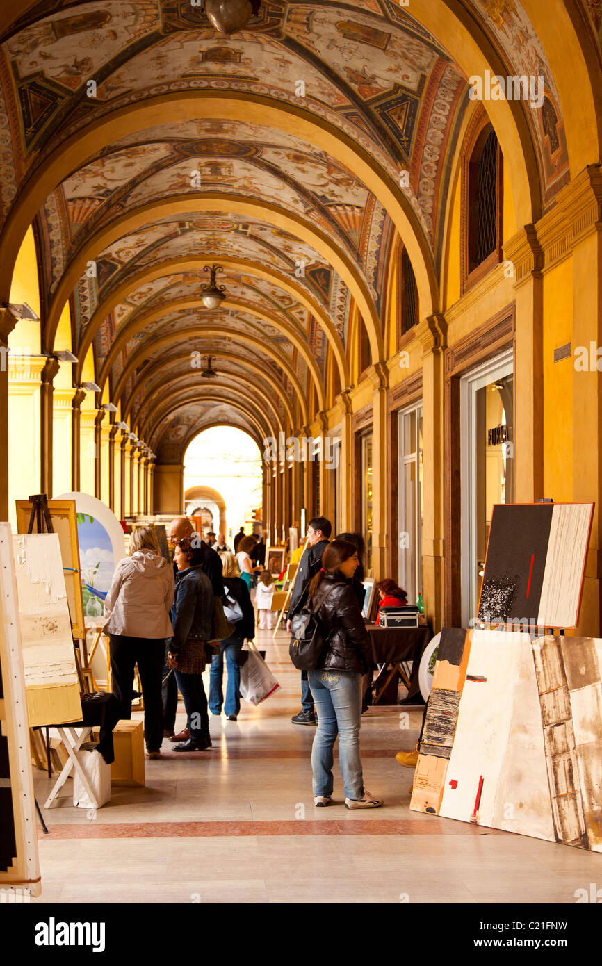 Shop lined arcade and Sunday art market in Bologna. Stock Photo