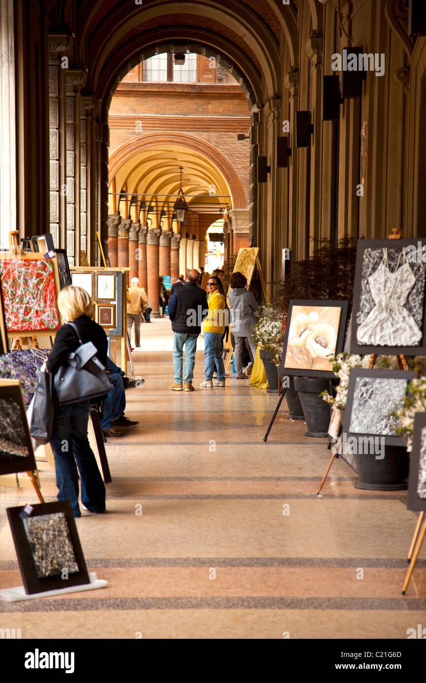 Shop lined arcade and Sunday art market in Bologna. Stock Photo