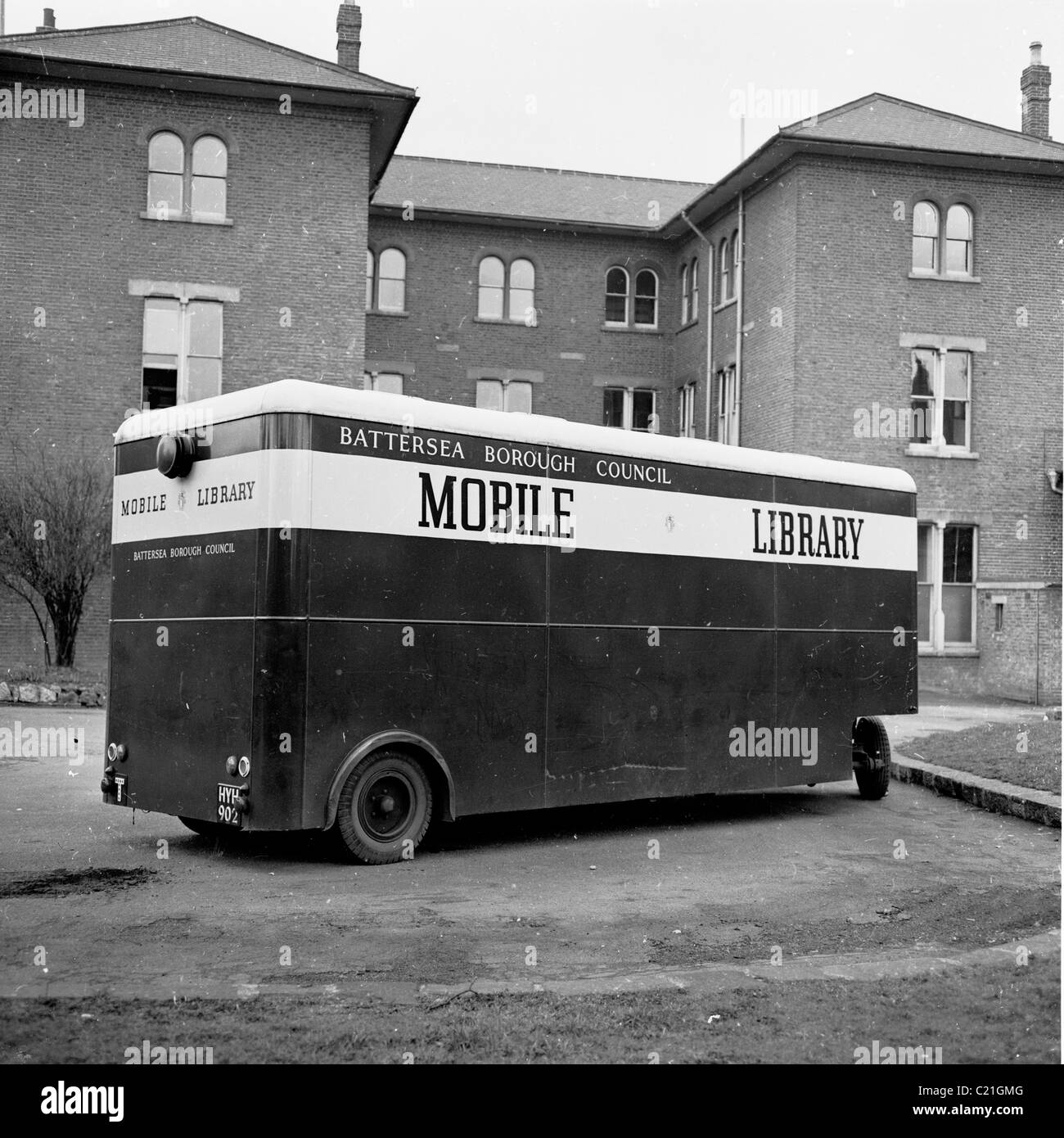1950s, England. Mobile Library run by Battersea Borough Council outside a block of flats in this picture by J Allan Cash. Stock Photo