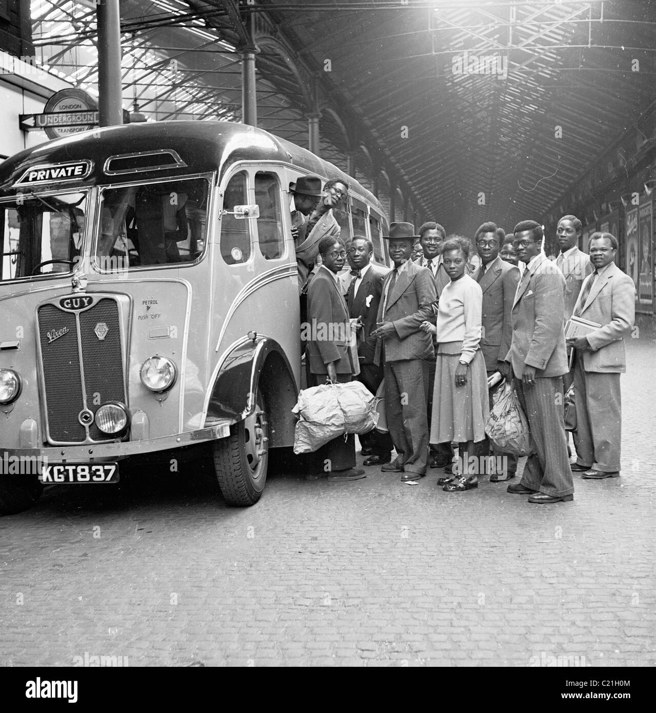 1950, London and newly arrived overseas immigrants from the Caribbean at Victoria train station await to board their transport, a Guy Vixen coach. Stock Photo