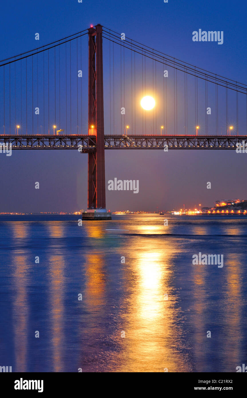 Portugal, Lisbon: Ponte 25 de Abril over river Tagus  with full moon Stock Photo