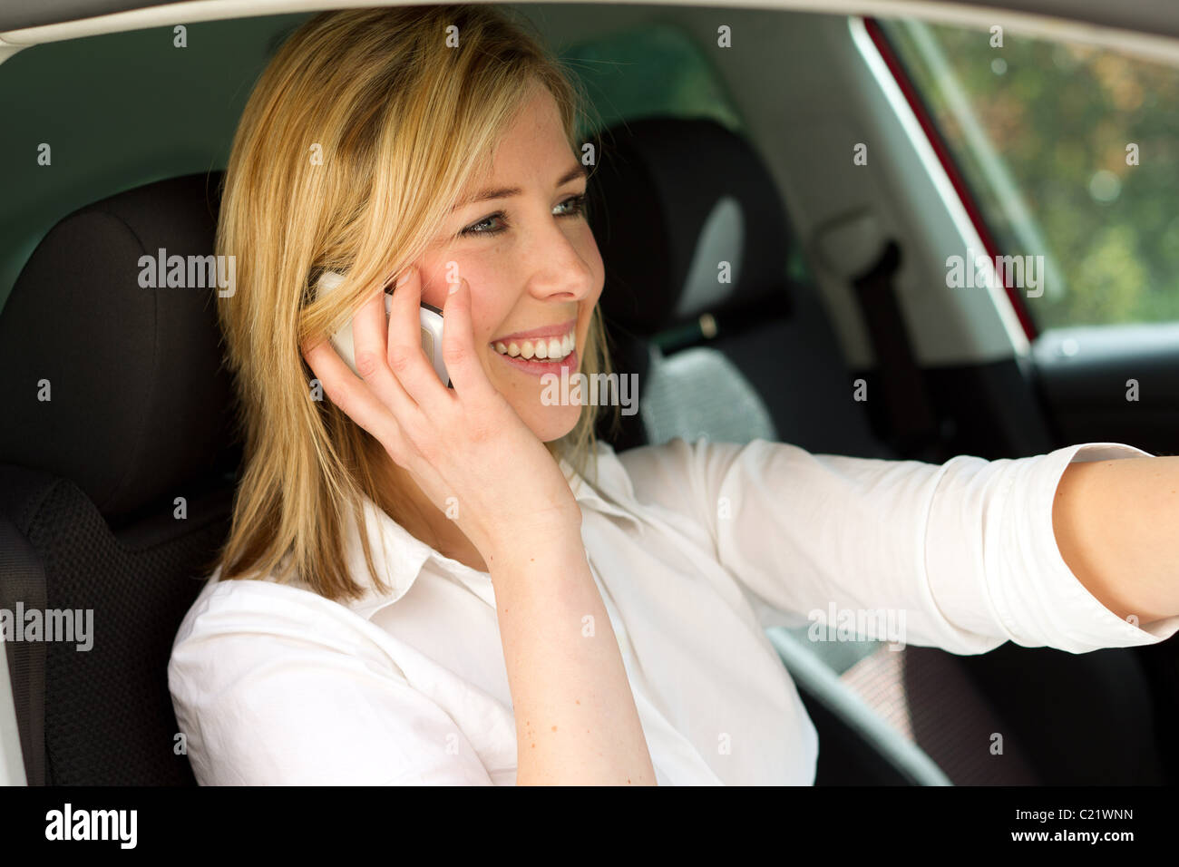 Woman chatting on phone sat in car Stock Photo