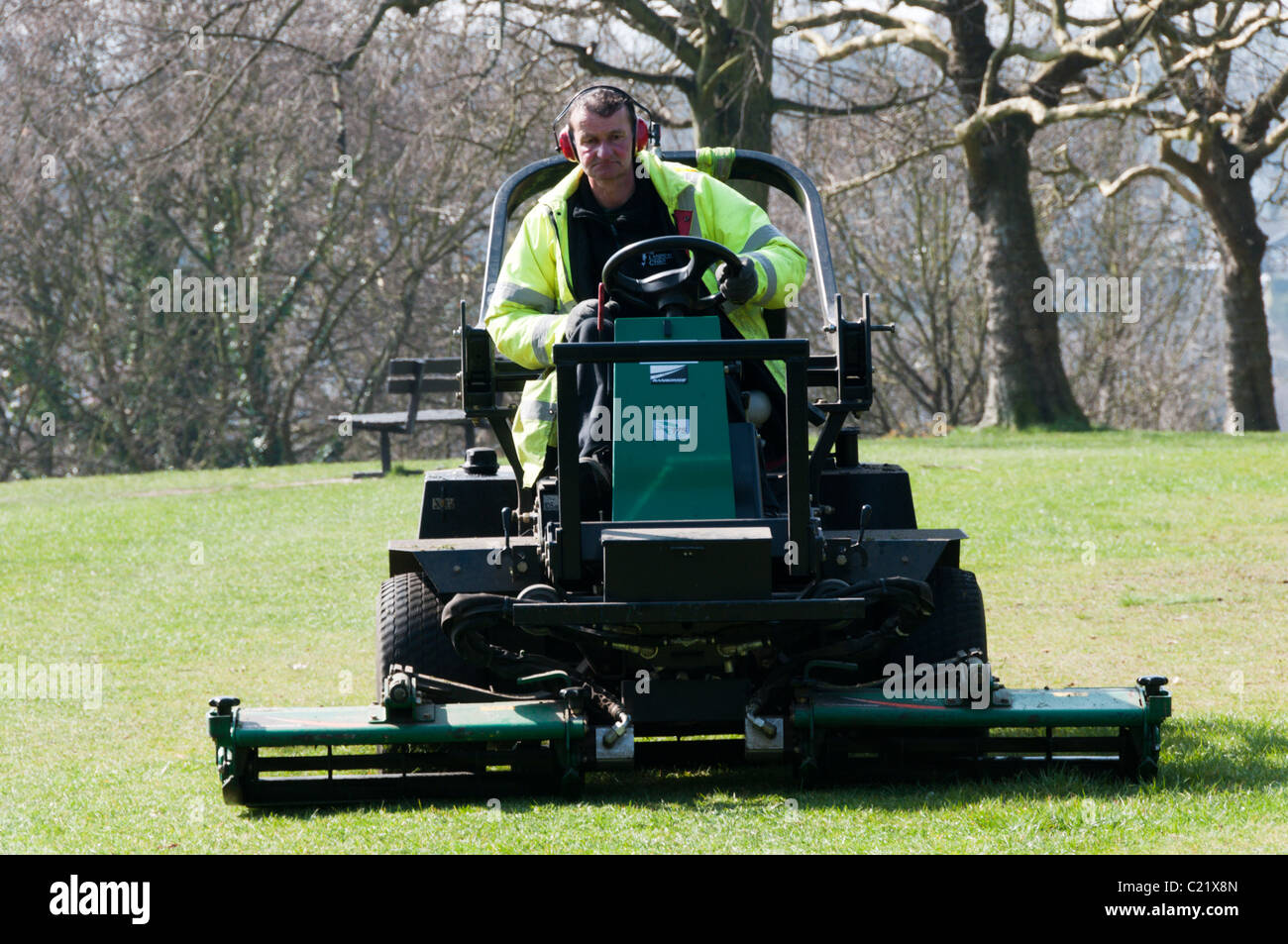 A gardener mows the grass in a public park in Bromley, Kent Stock Photo