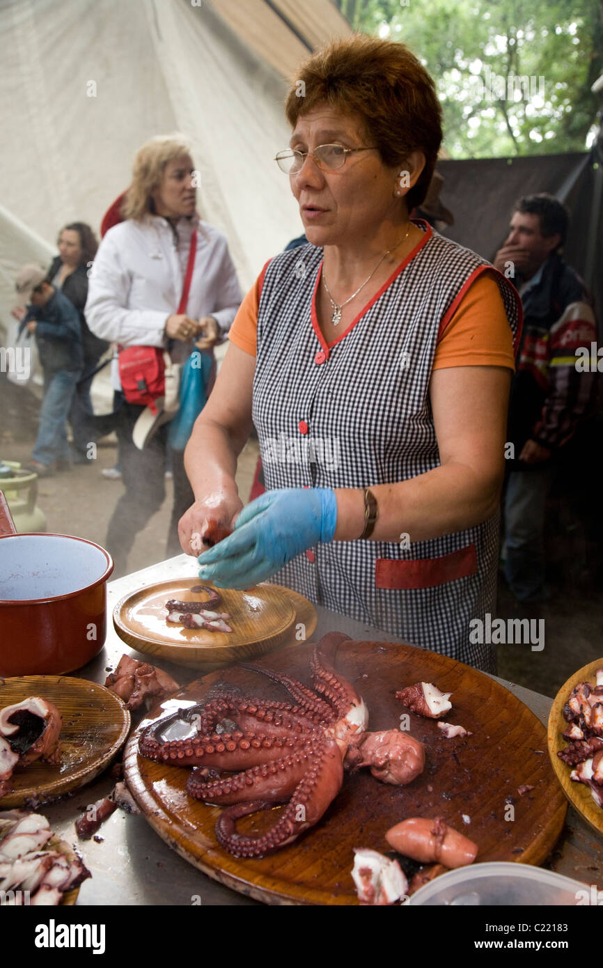 A woman prepares pulpo a la gallega (boiled octopus), a typical regional dish of Galicia, northwest Spain Stock Photo