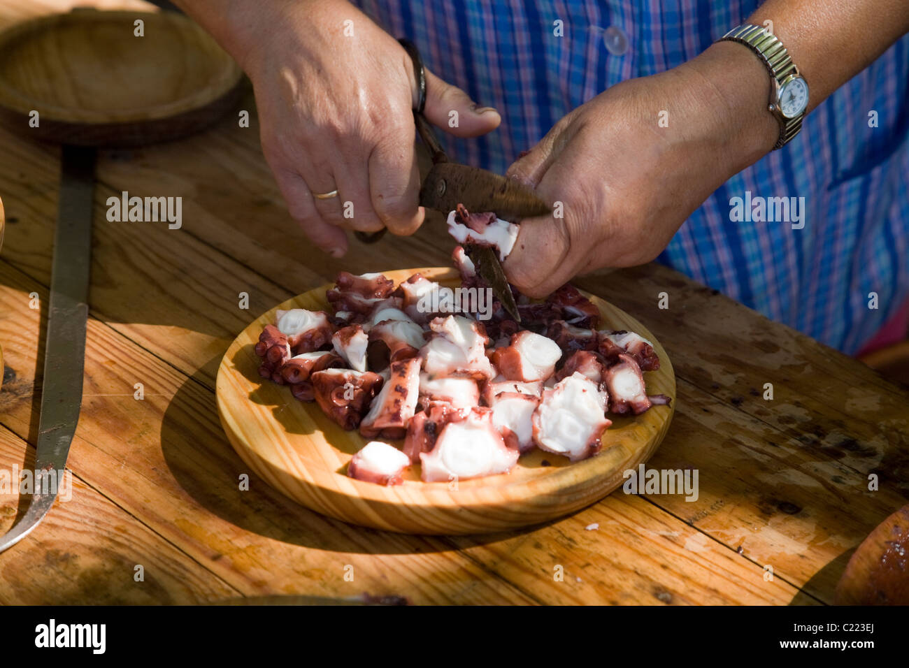 A woman prepares a traditional dish of Pulpo Gallego (Gallician Octopus) Stock Photo
