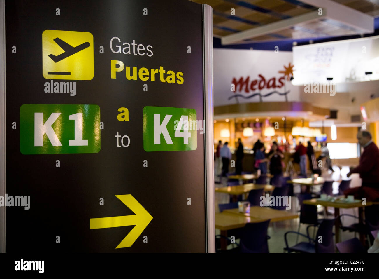 Sign to airport departure / departures gate / gates in the lounge with cafe  / restaurant at Seville / Seville airport. Spain Stock Photo - Alamy
