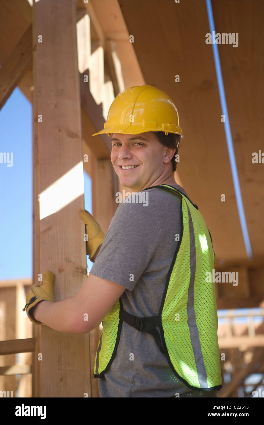 Labourer positioning plank of wood Stock Photo