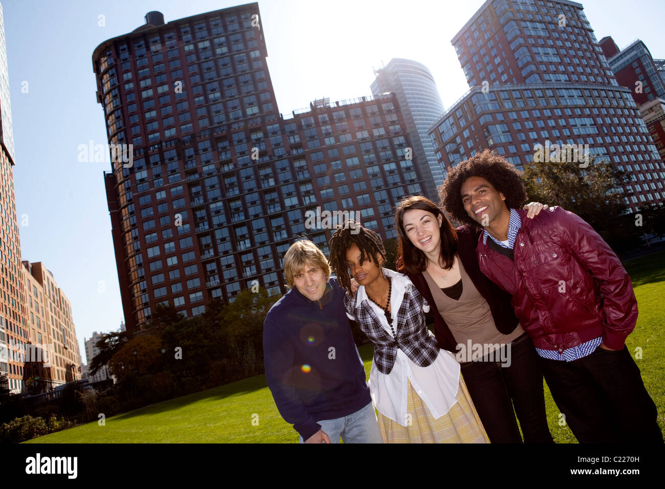 A group of people in front of an apartment building taken into the sun with solar flare Stock Photo