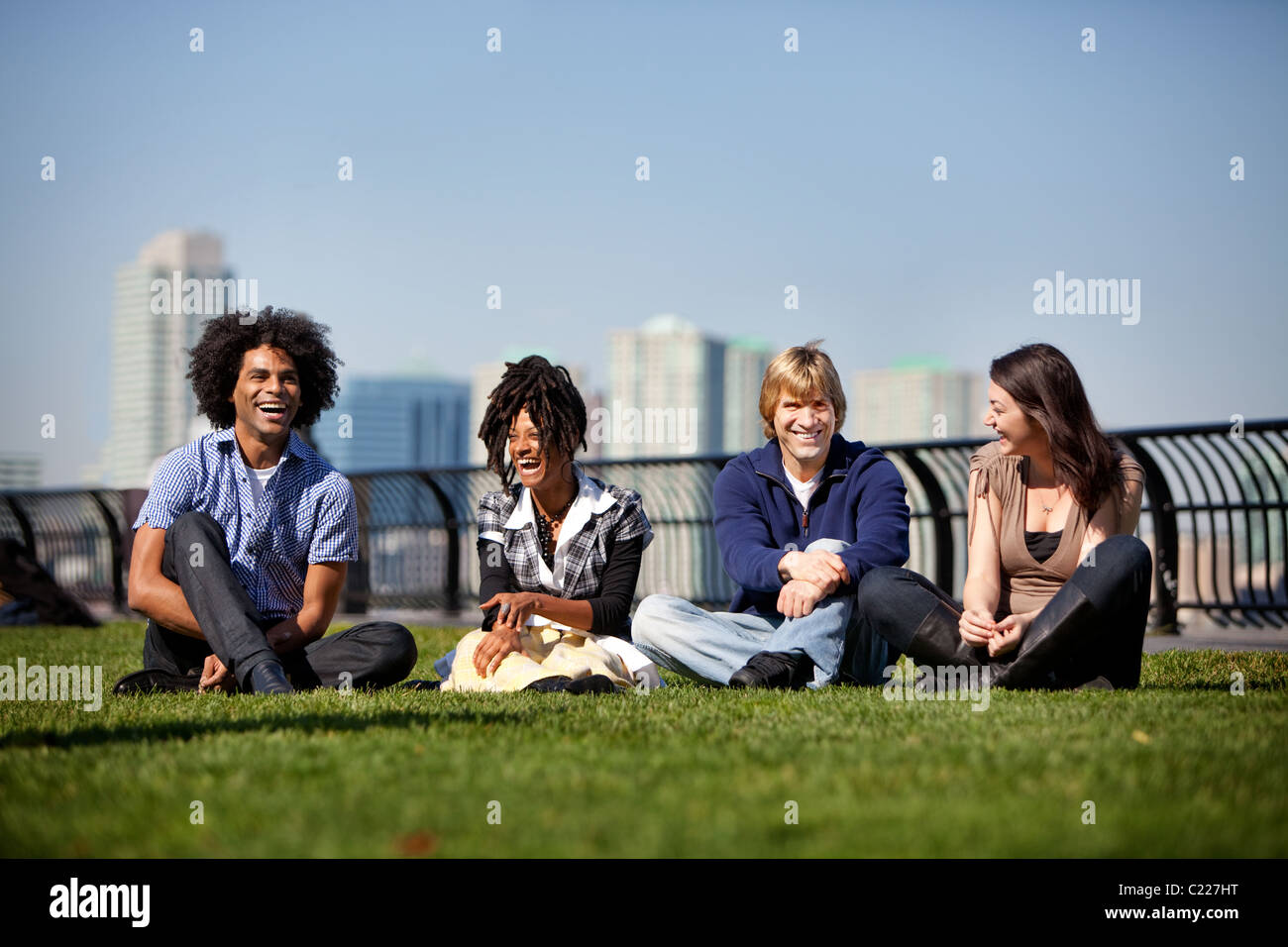 A group of friends in a city park talking and laughing Stock Photo - Alamy