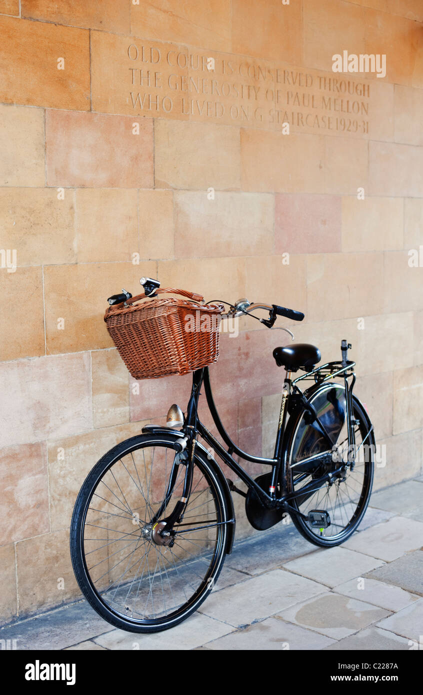 A typical Cambridge bicycle leans against the wall of a Cambridge College. Stock Photo