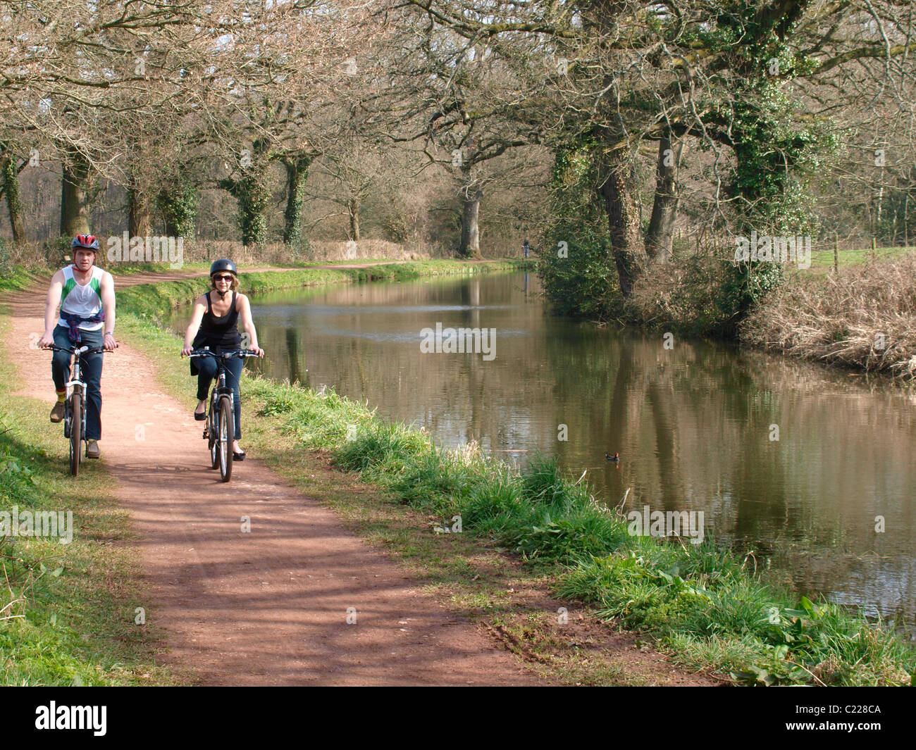 Couple cycling along The Grand Western Canal, Tiverton, Devon, UK Stock Photo