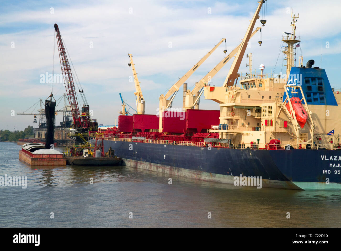 Crane loading a barge with coal on the Mississippi River at New Orleans, Louisiana, USA. Stock Photo