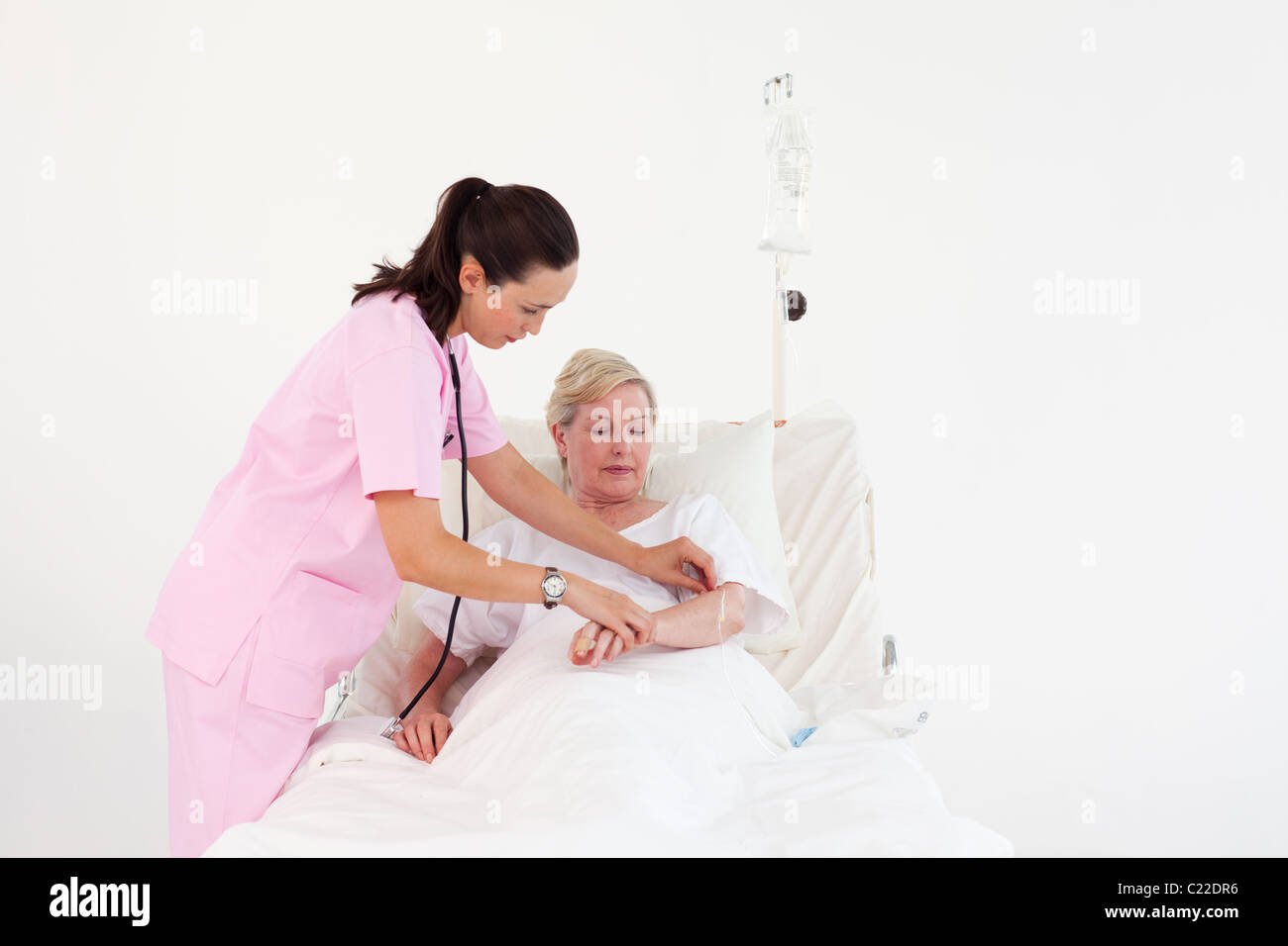 A female doctor checking the pulse of a smiling woman Stock Photo - Alamy