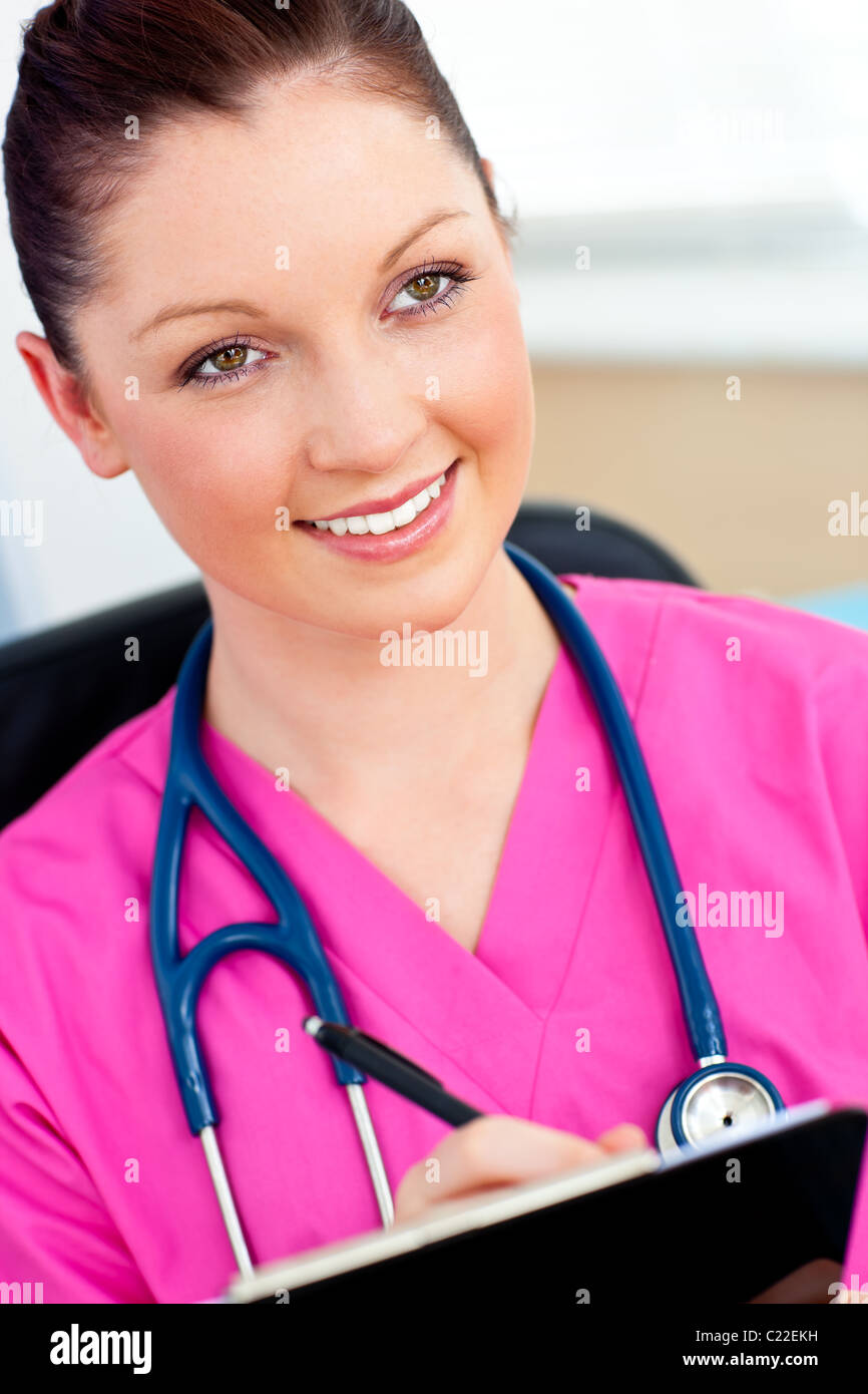 Charming female nurse holding a clipboard Stock Photo - Alamy