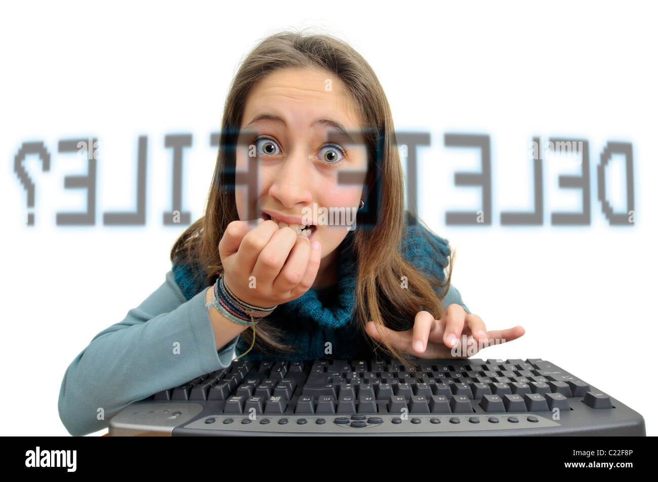 Stressed young girl in front of a computer screen with the question: Delete file? Stock Photo