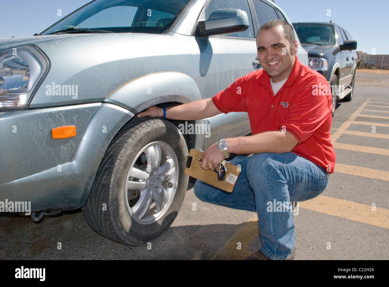 An employee at Discount Tire checks tread depth. Stock Photo