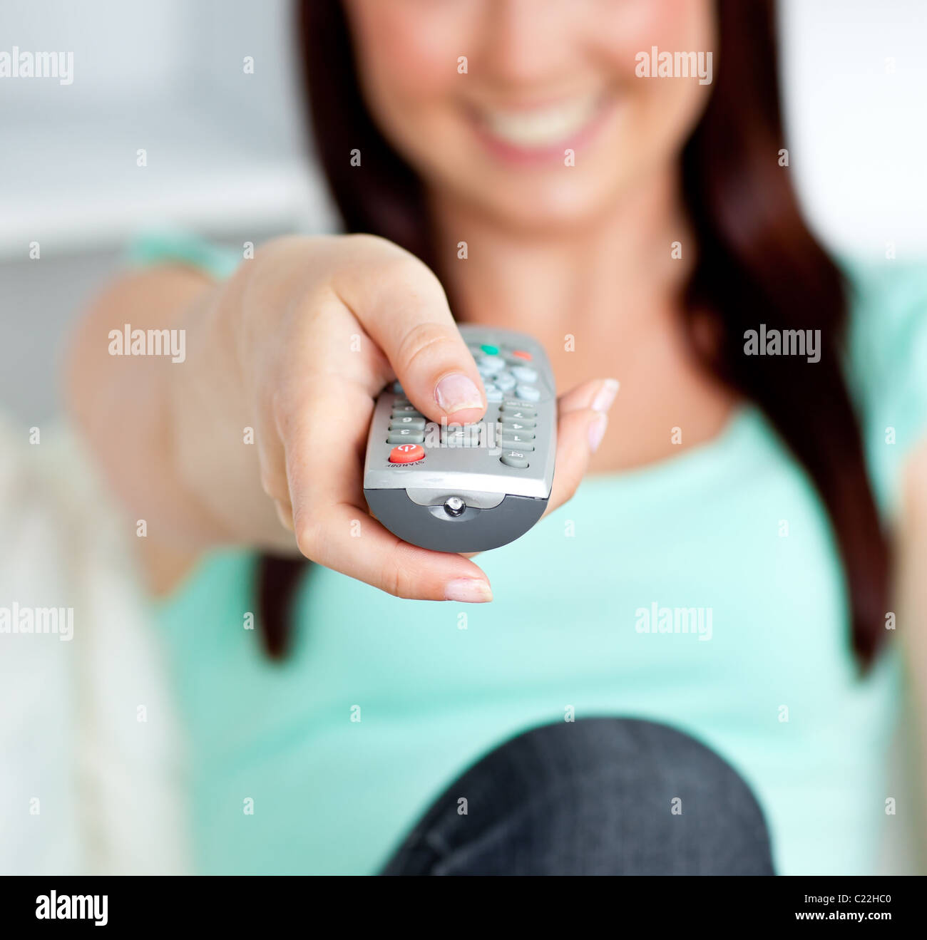 Someone Hoding A Remote Close-up of a smiling woman hoding a remote in the living-room Stock ...
