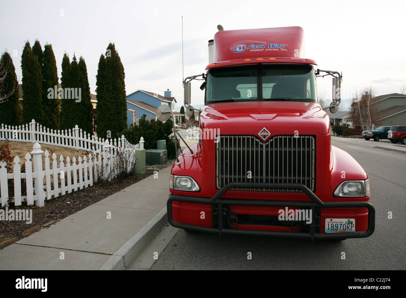 Red freight truck parked in residential neighborhood. Stock Photo