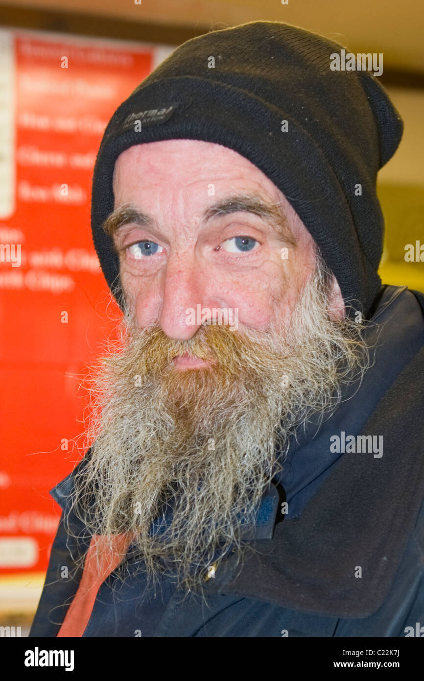 Covent Garden , very old man with nicotine stained grey or gray beard &  doleful eyes at cafe or snack bar in Jubilee Market Stock Photo